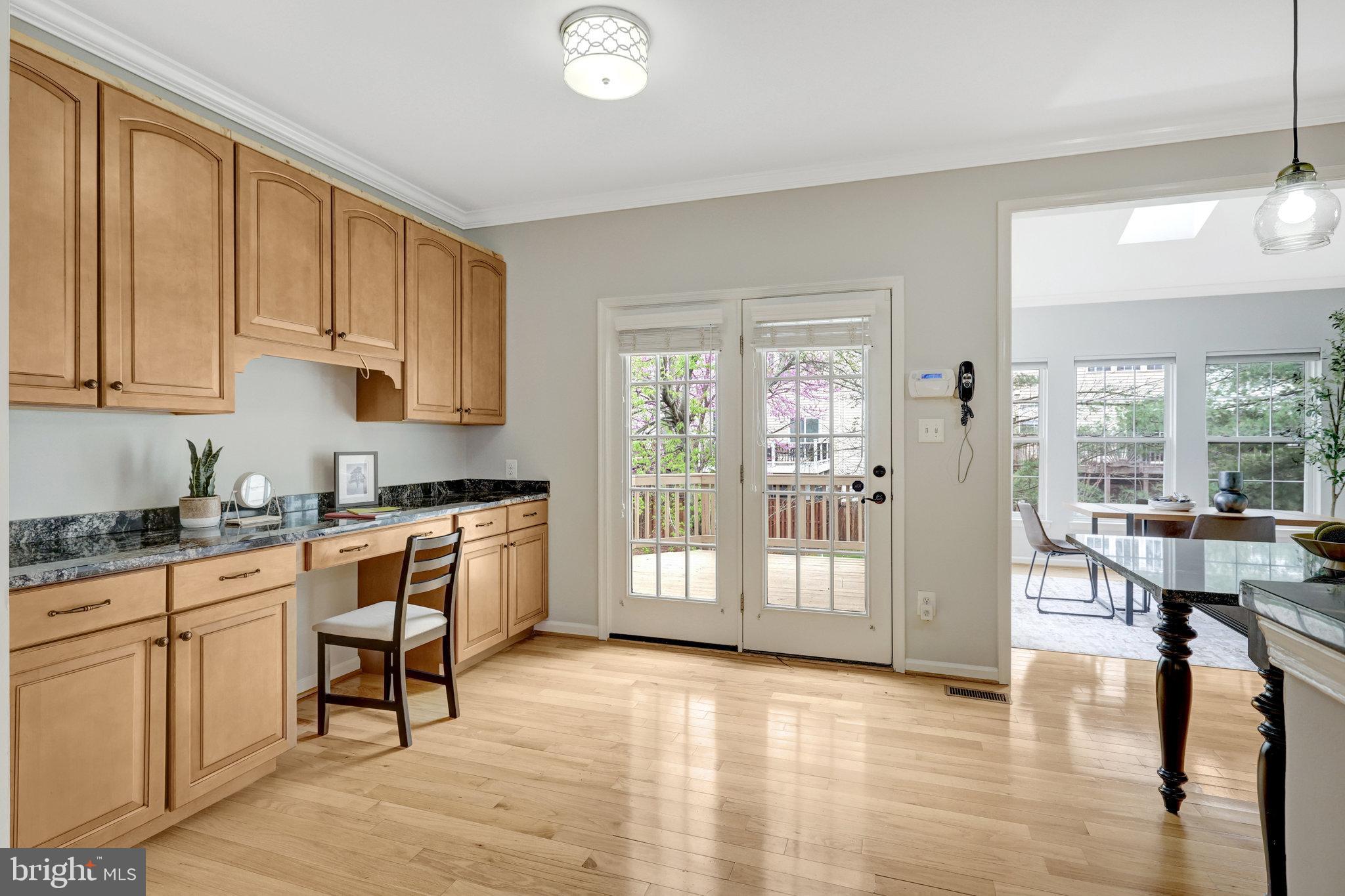 43233 Stillforest Terrace Ashburn, VA 20147 - Photo 4 of 24 a kitchen with stainless steel appliances granite countertop a stove top oven a sink dishwasher a dining table and chairs with wooden floor