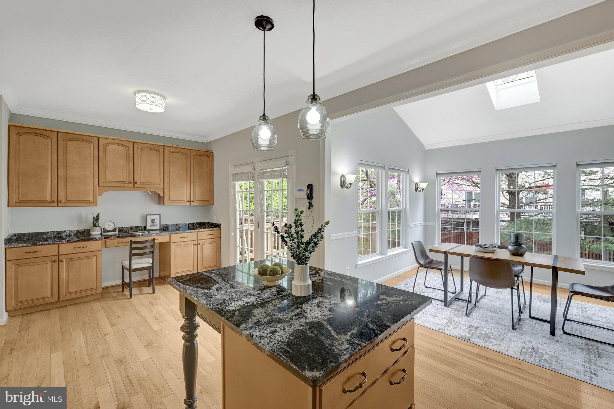 43233 Stillforest Terrace Ashburn, VA 20147 - Photo 8 of 24 a kitchen with stainless steel appliances granite countertop a stove oven and a dining table with wooden floor