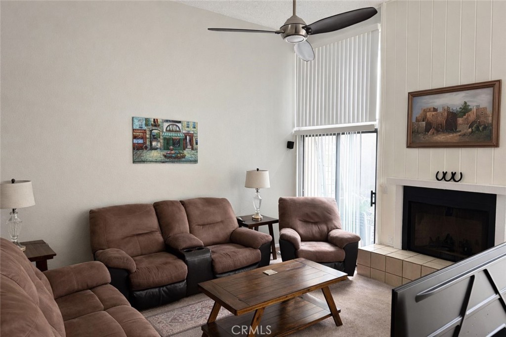 18697 Club Huntington Beach, CA 92648 - Photo 5 of 17 a living room with furniture a flat screen tv and a fireplace