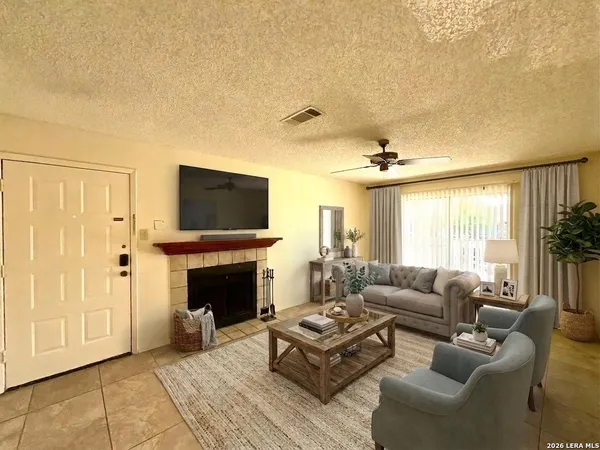 a living room with furniture a fireplace and a flat screen tv