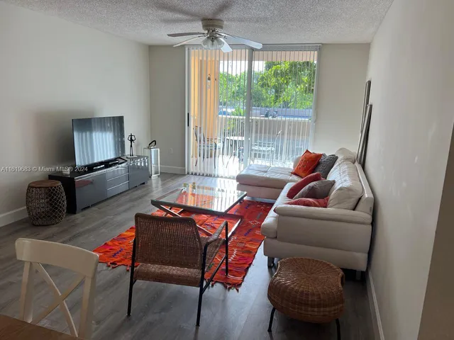 a living room with furniture a flat screen tv and a large window
