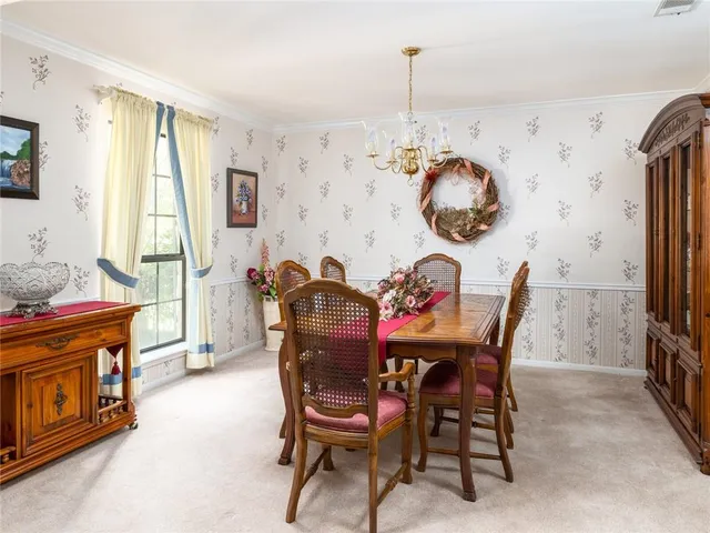 a view of a dining room with furniture and a chandelier