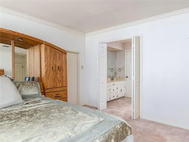a bedroom with a bed and a large mirror