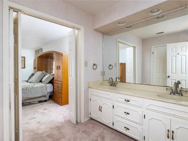 a en suite bathroom with a granite countertop sink and a mirror