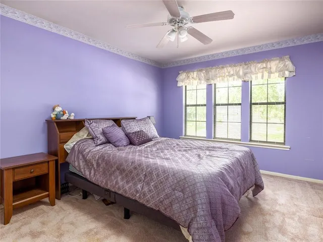 a bedroom with a bed and a ceiling fan