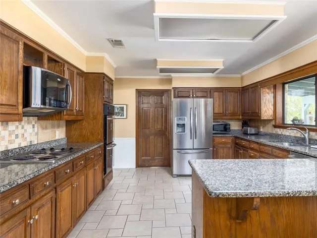 a kitchen with stainless steel appliances granite countertop a sink stove and refrigerator