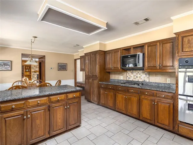 a kitchen with stainless steel appliances granite countertop a sink and cabinets