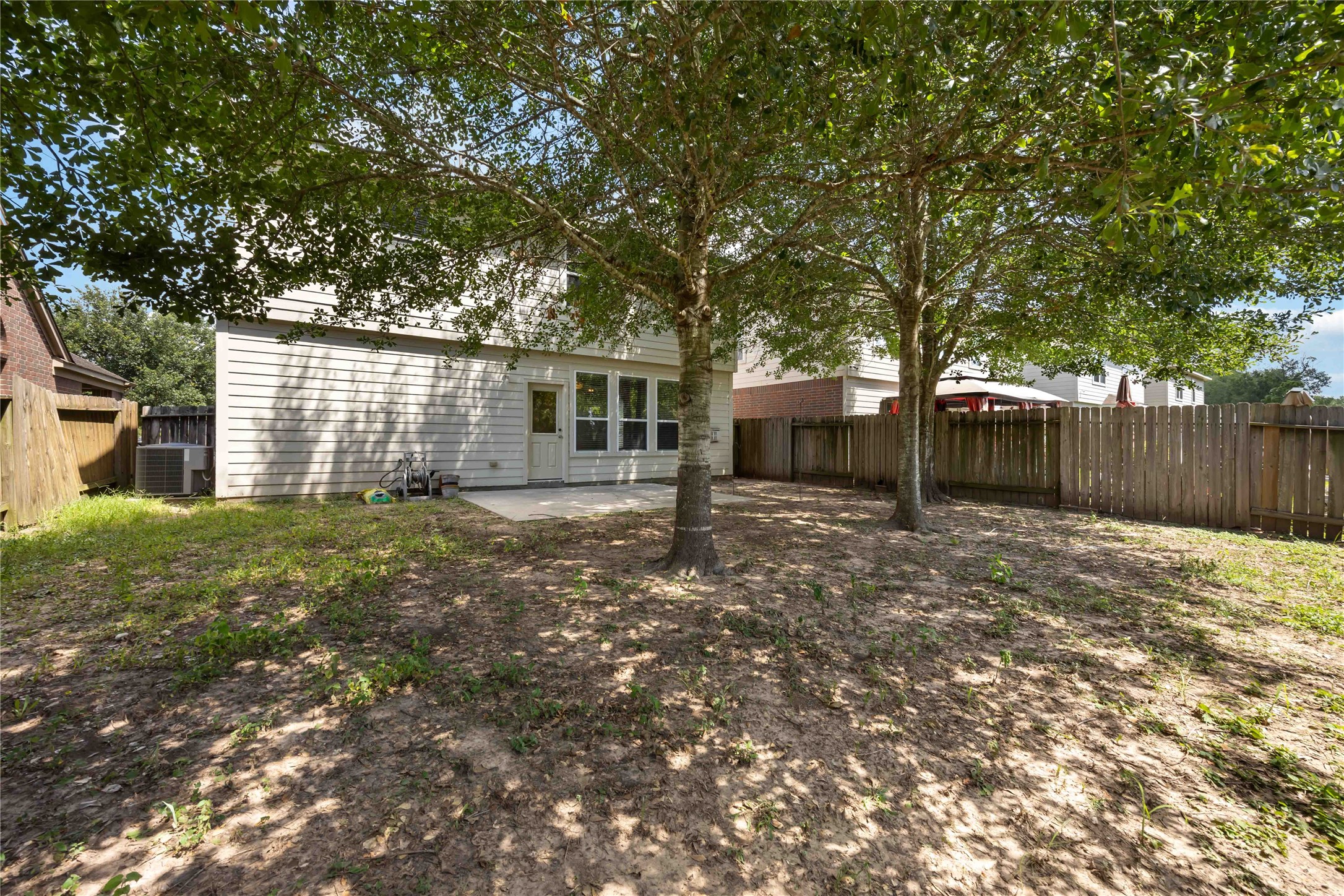 29526 Winton Wood Way Spring, TX 77386 - Photo 28 of 29 Alternate view of the backyard showcasing mature trees, generous outdoor space, and a fully fenced yard.