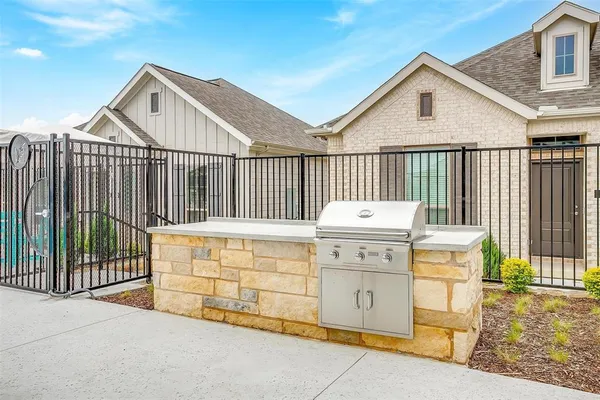 a view of a wooden house with a small yard and wooden fence