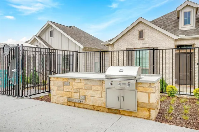a view of a wooden house with a small yard and wooden fence