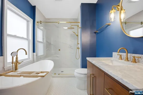 a bathroom with a granite countertop sink a toilet and a mirror