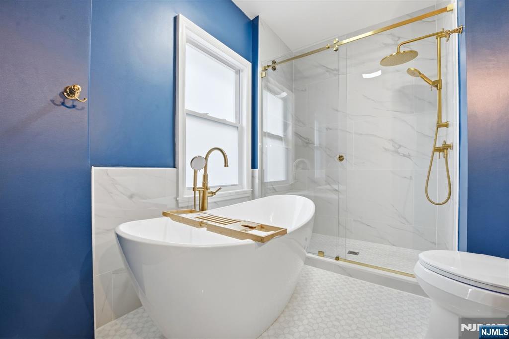 16 Munn Street, Unit 2 Montclair, NJ 07042 - Photo 17 of 21 a bathroom with a white bath tub a mirror and a shower