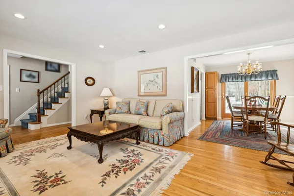 a dining room with stainless steel appliances kitchen island granite countertop a refrigerator and wooden cabinets