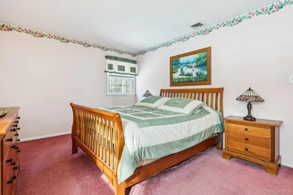 a spacious bedroom with a bed and a chandelier