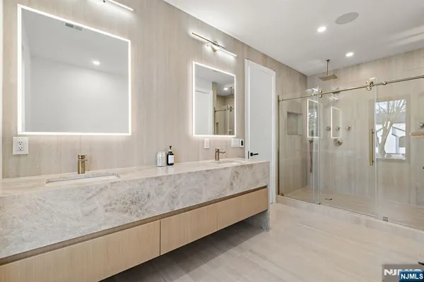 a bathroom with a granite countertop sink mirror and shower