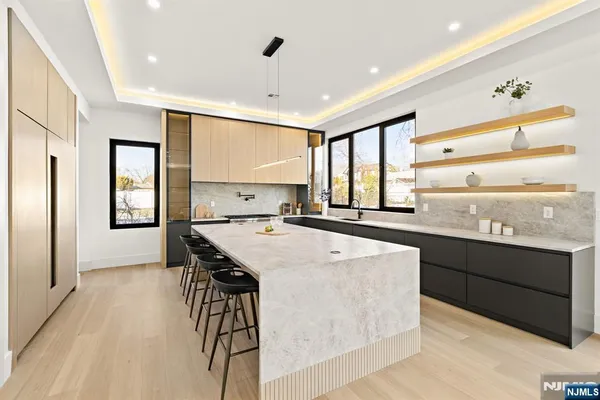 a kitchen with kitchen island a stove a sink a refrigerator and windows