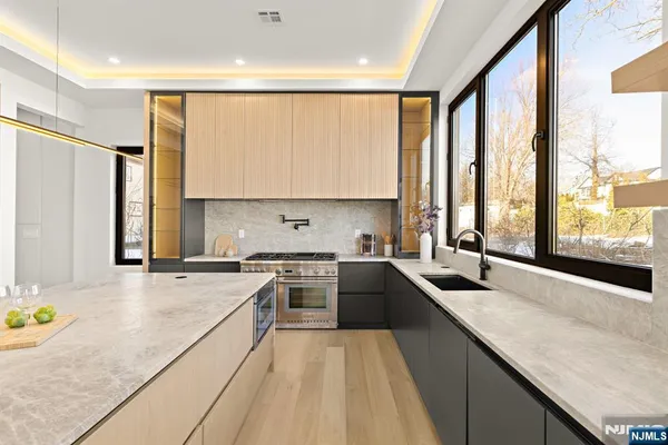 a kitchen with stainless steel appliances granite countertop a sink a stove and a refrigerator