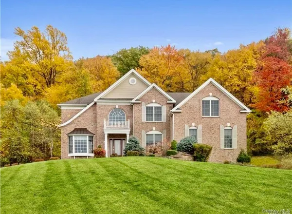 a front view of a house with a yard and trees