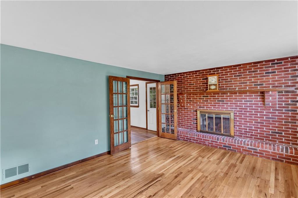 97 Emery Road Fredericktown, PA 15333 - Photo 4 of 23 a view of an empty room with wooden floor and a fireplace