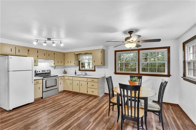 a kitchen with a table chairs refrigerator and cabinets