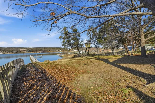 a view of a yard with wooden fence