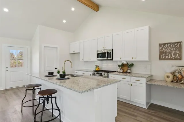 a kitchen with sink a stove and cabinets