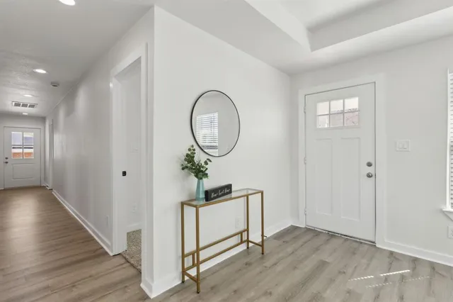 a living room with wooden floor and entryway