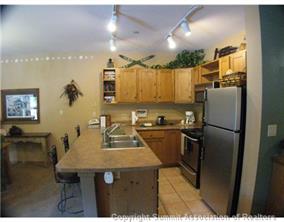 195 River Run Road, Unit 8004 Keystone, CO 80435 - Photo 3 of 16 a kitchen with refrigerator and chairs