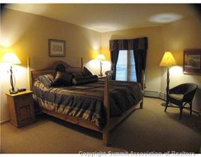 195 River Run Road, Unit 8004 Keystone, CO 80435 - Photo 7 of 16 a spacious bedroom with a bed a lamp and window