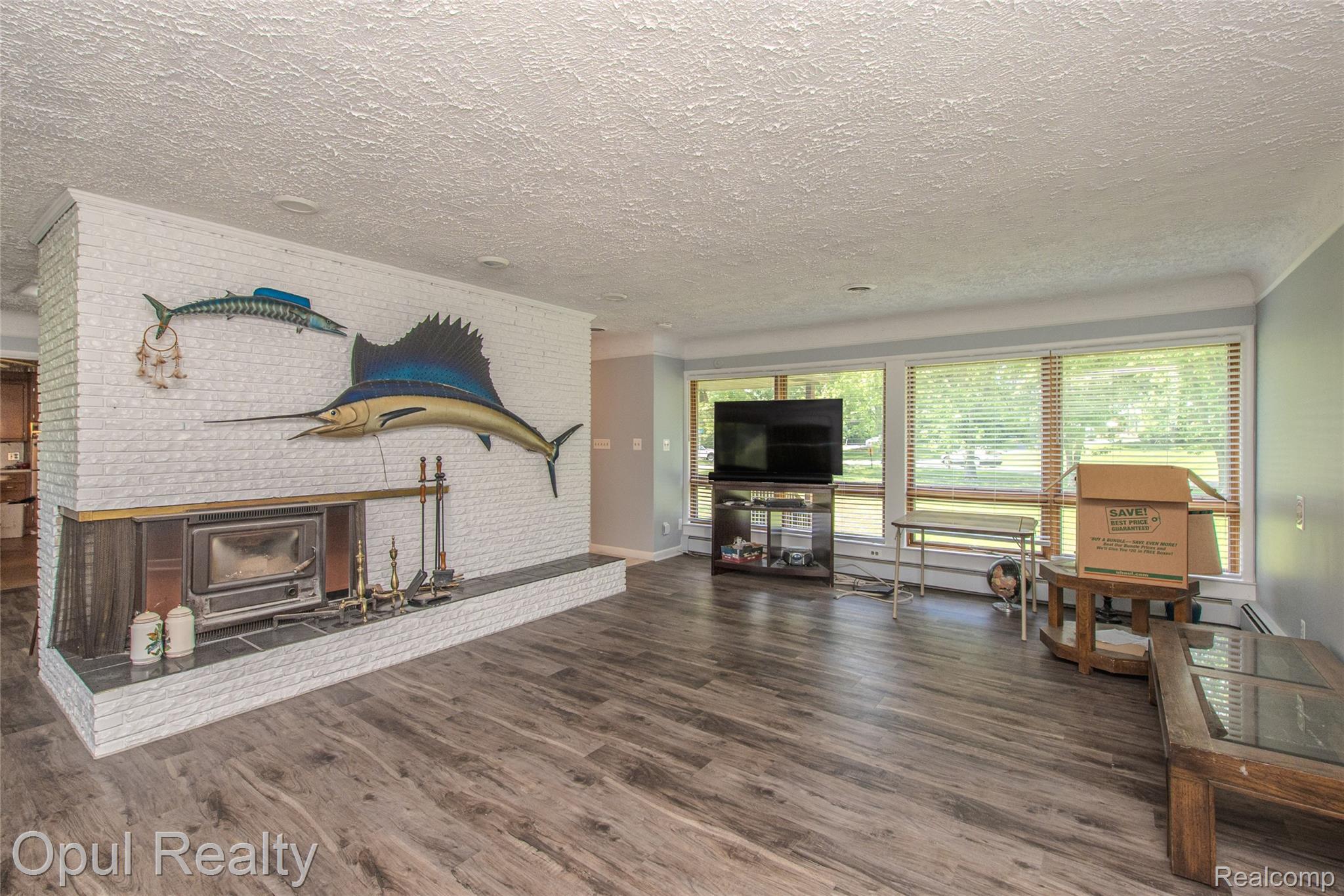 6455 Norham Road Bloomfield Hills, MI 48301 - Photo 46 of 93 Spacious living area featuring a prominent white brick fireplace with a dark-toned hearth