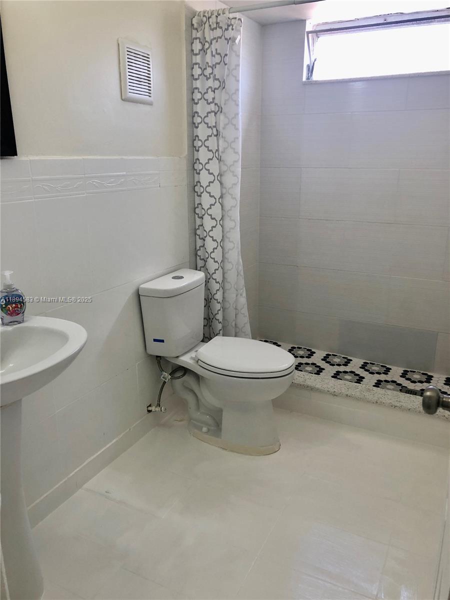 1010 Southwest 99th Avenue Pembroke Pines, FL 33025 - Photo 13 of 22 a white toilet sitting next to a bathroom sink