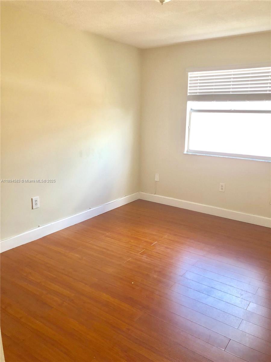 1010 Southwest 99th Avenue Pembroke Pines, FL 33025 - Photo 15 of 22 an empty room with wooden floor and windows