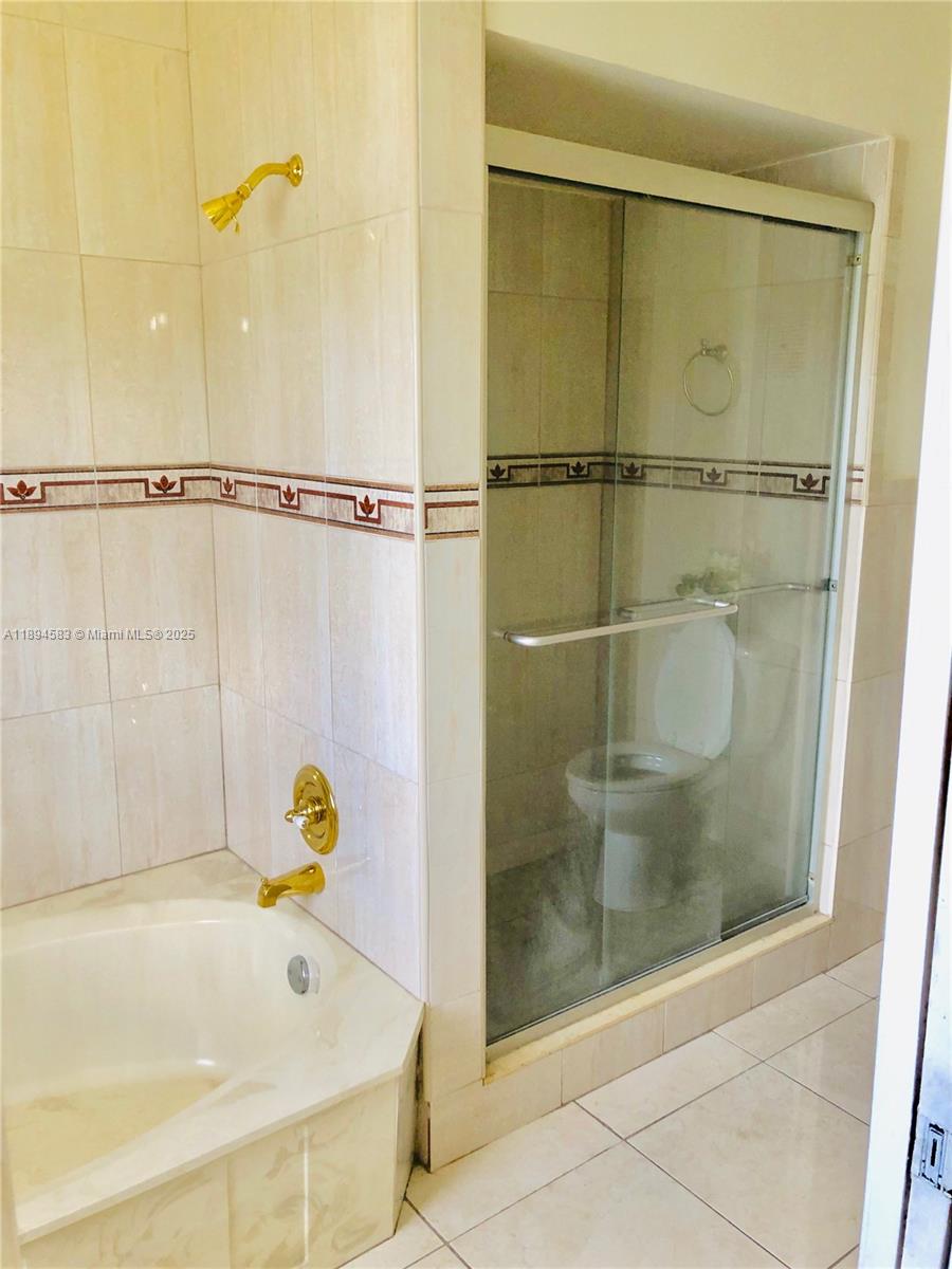 1010 Southwest 99th Avenue Pembroke Pines, FL 33025 - Photo 16 of 22 a bathroom with a tub and a shower