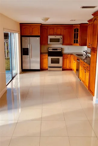 a kitchen with stainless steel appliances a stove a sink and a microwave