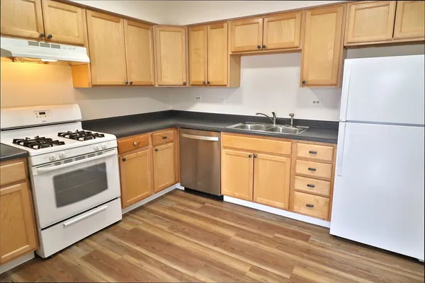 a kitchen with granite countertop a sink stainless steel appliances and cabinets