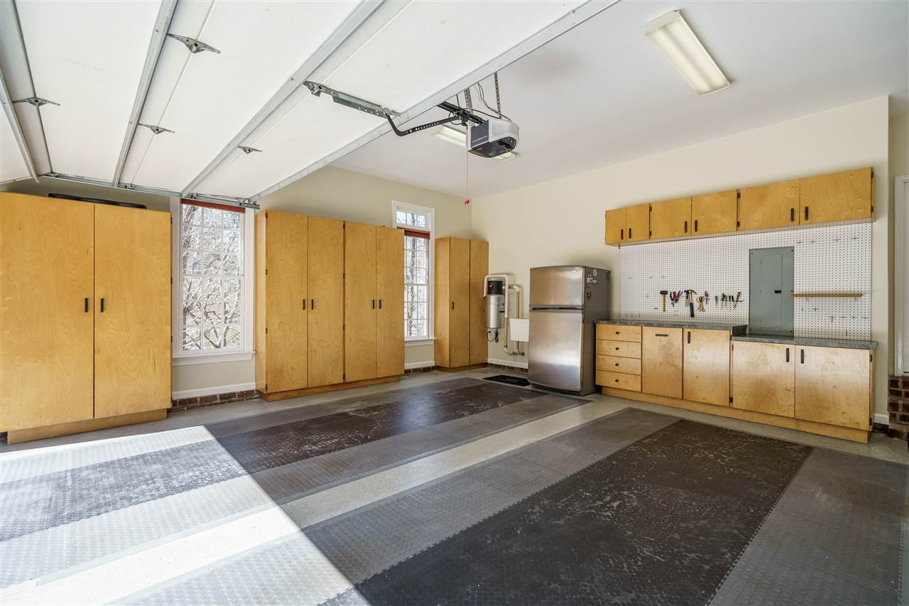3916 Hemsbury Way Raleigh, NC 27612 - Photo 27 of 30 Garage has workshop with custom cabinets for plenty of storage, epoxy coating on garage floor, utility sink Workshop in Garage