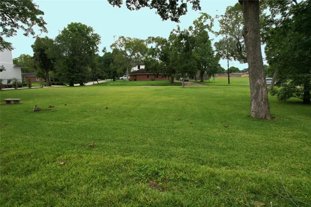 a view of grassy field with benches and trees all around