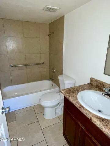 a bathroom with a granite countertop sink a toilet and bathtub