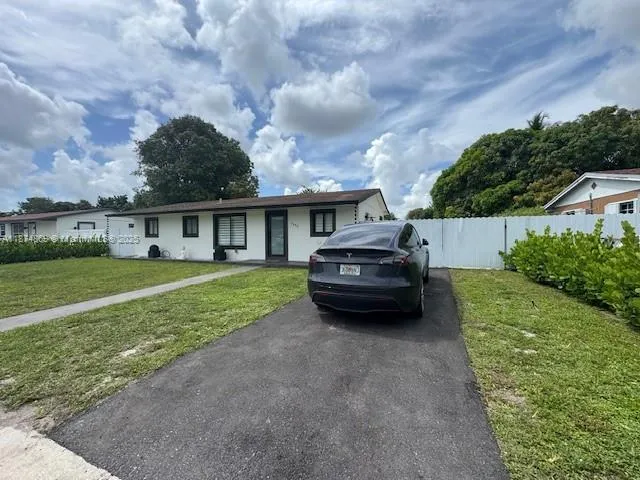 a view of house with garden and parking area