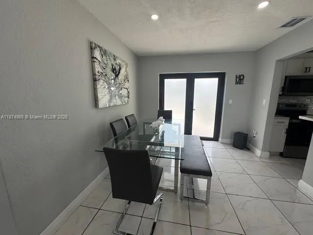 a living room with furniture a flat screen tv and a window