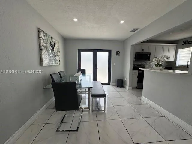 a living room with furniture a flat screen tv and a window
