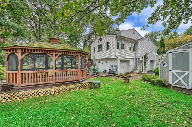 a view of a chair and table in backyard of the house