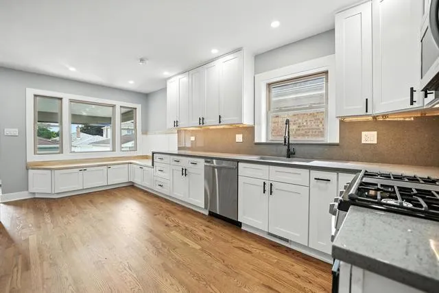 a kitchen with a stove a sink and a window