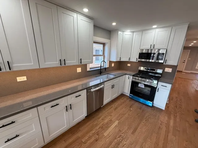 a kitchen with stainless steel appliances granite countertop a stove a sink and a microwave