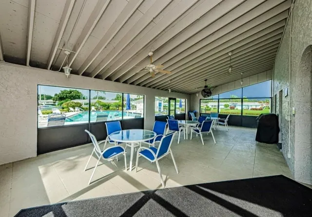 a view of a swimming pool with a lawn chairs and potted plants