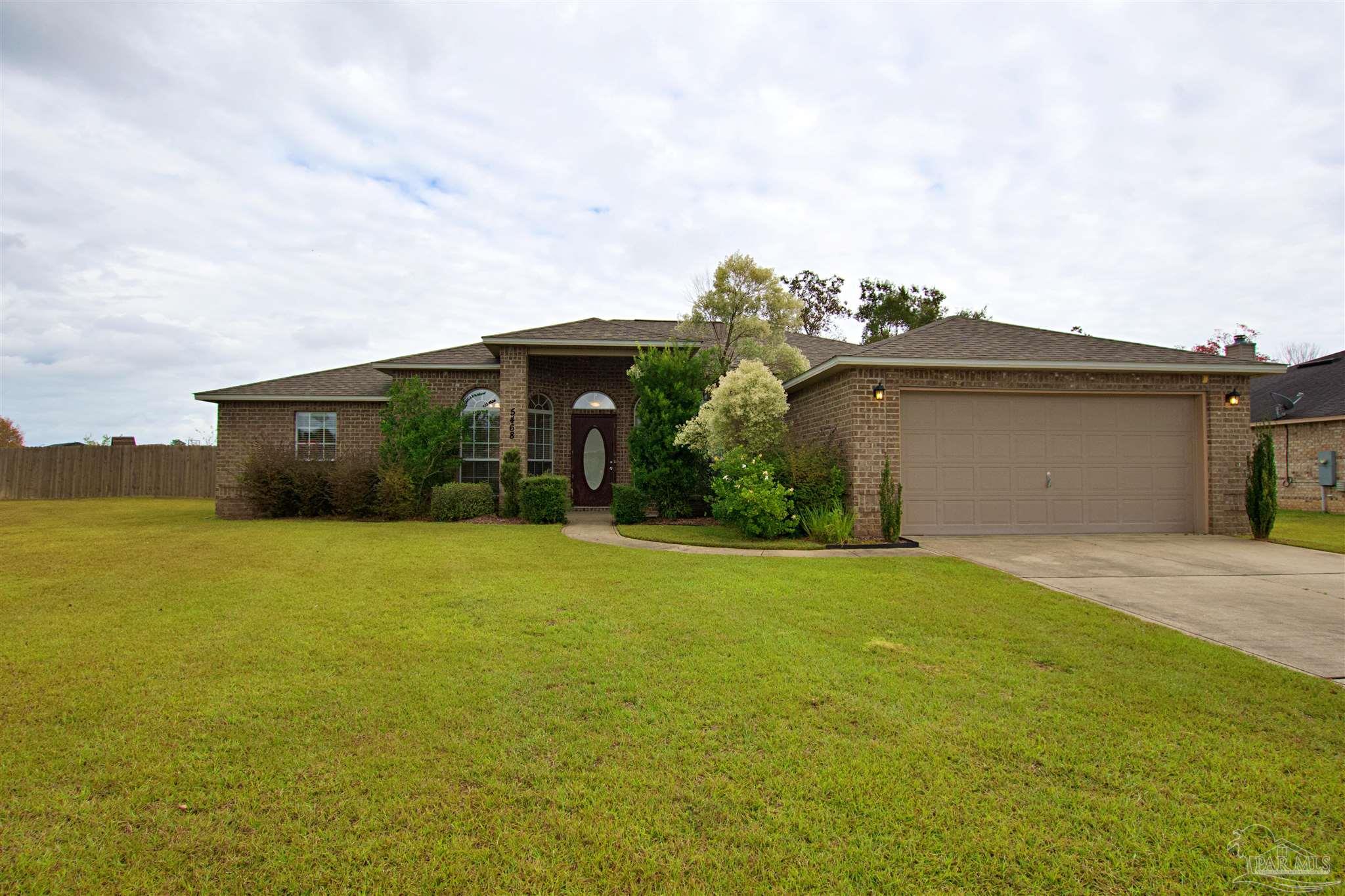 a front view of a house with a garden and yard