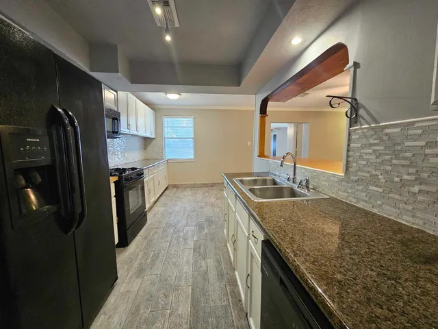 a kitchen with stainless steel appliances granite countertop a sink and stove