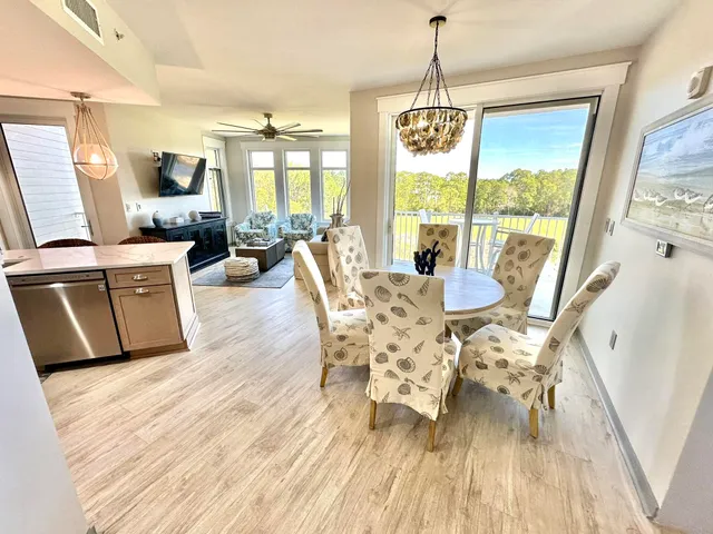 a dining room with wooden floor a chandelier a wooden table and chairs