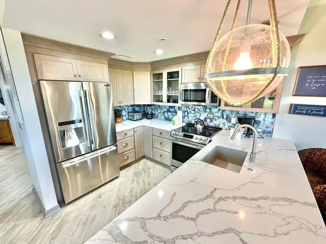 a kitchen with stainless steel appliances a refrigerator a sink a stove and cabinets