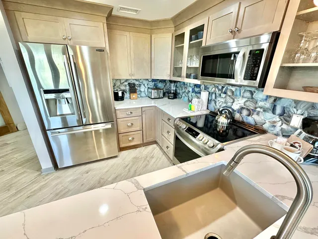 a kitchen with stainless steel appliances granite countertop a refrigerator and a stove top oven